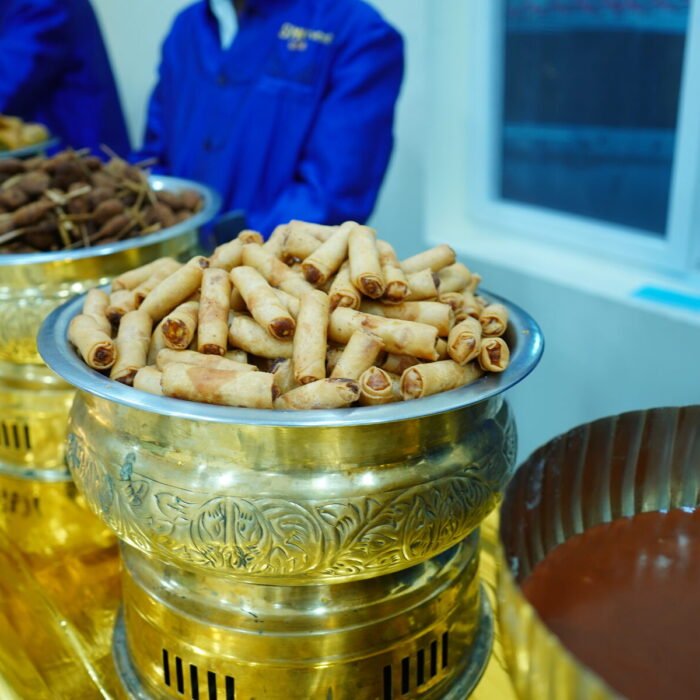 Fried rolls and dates counter being served by catering staff